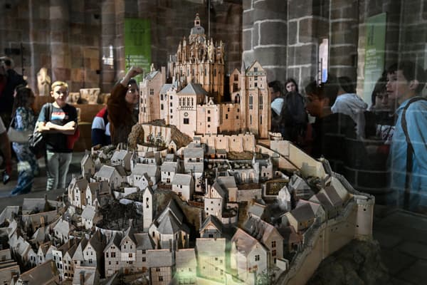 Les visiteurs observent la maquette du Mont-Saint-Michel dans le cadre de l'exposition "La résidence de l'Archange, 1000 ans d'histoire et de création à l'abbaye du Mont-Saint-Michel", le 23 mai 2023.